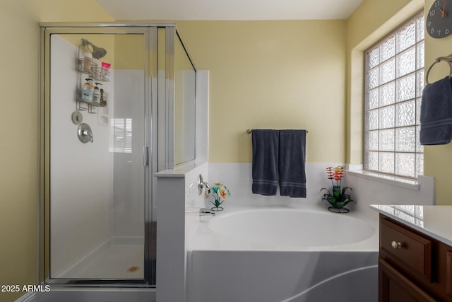 full bathroom with a bath, vanity, and a shower stall