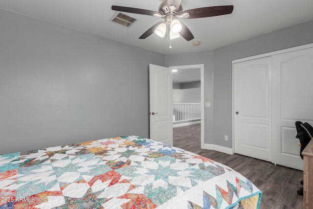 bedroom featuring a closet, visible vents, baseboards, wood finished floors, and a ceiling fan