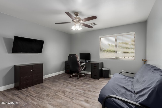 home office with baseboards, visible vents, light wood-style flooring, and ceiling fan