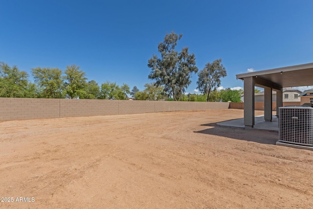 view of yard with a fenced backyard, central AC, and a patio area