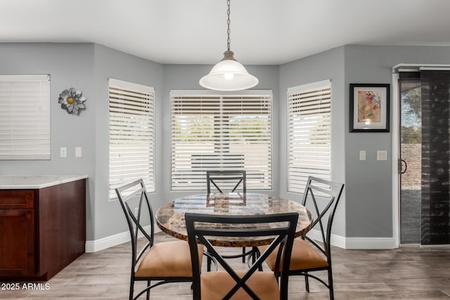 dining room featuring baseboards and light wood finished floors