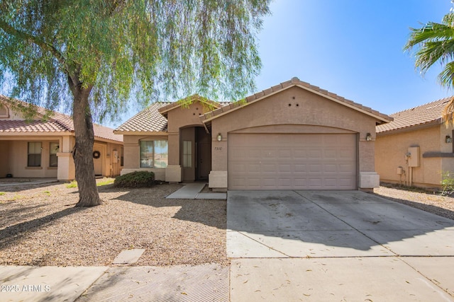 7310 N 68th Ln, Glendale, AZ 85303 - mediterranean / spanish home featuring stucco siding, a garage, concrete driveway, and a tile roof