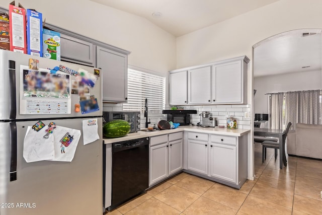 7310 N 68th Ln, Glendale, AZ 85303 - kitchen with freestanding refrigerator, black dishwasher, light countertops, backsplash, and light tile patterned floors