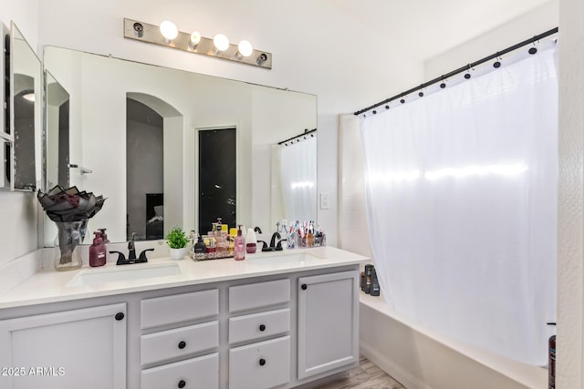 7310 N 68th Ln, Glendale, AZ 85303 - full bath featuring shower / tub combo with curtain, double vanity, and wood finished floors
