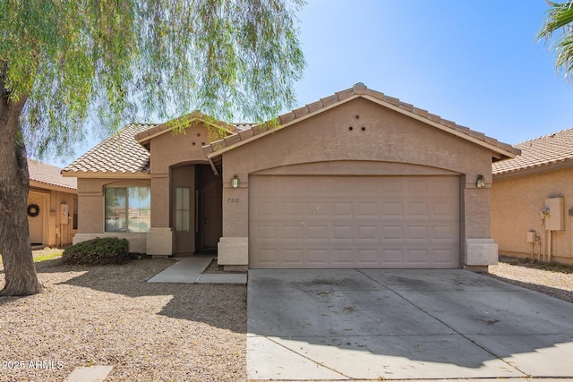 7310 N 68th Ln, Glendale, AZ 85303 - mediterranean / spanish-style home featuring a tile roof, stucco siding, a garage, and concrete driveway