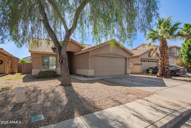 7310 N 68th Ln, Glendale, AZ 85303 - mediterranean / spanish-style house with an attached garage, stucco siding, a tiled roof, and driveway