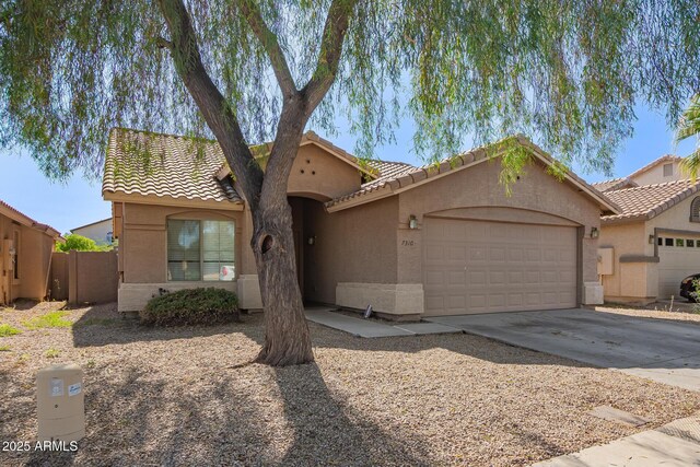 7310 N 68th Ln, Glendale, AZ 85303 - mediterranean / spanish-style home with an attached garage, stucco siding, and a tile roof