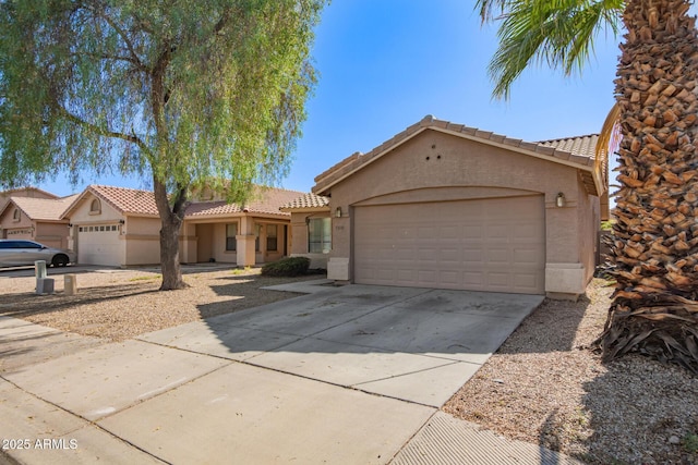 7310 N 68th Ln, Glendale, AZ 85303 - view of front facade featuring stucco siding, a tile roof, an attached garage, and concrete driveway