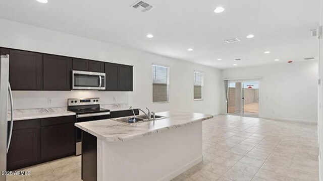1337 W Hess Ave, Coolidge, AZ 85128 - kitchen featuring appliances with stainless steel finishes, recessed lighting, a sink, light tile patterned floors, and a center island with sink