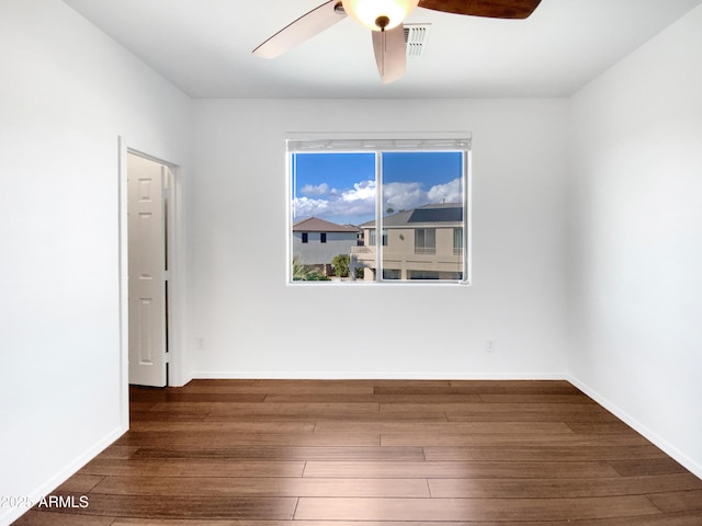 spare room featuring dark wood-type flooring and ceiling fan