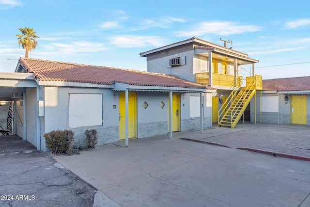 view of front of property with a wall mounted AC