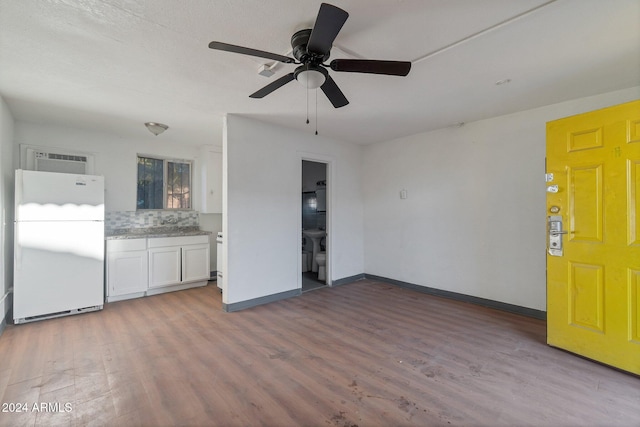 unfurnished living room with ceiling fan and hardwood / wood-style flooring