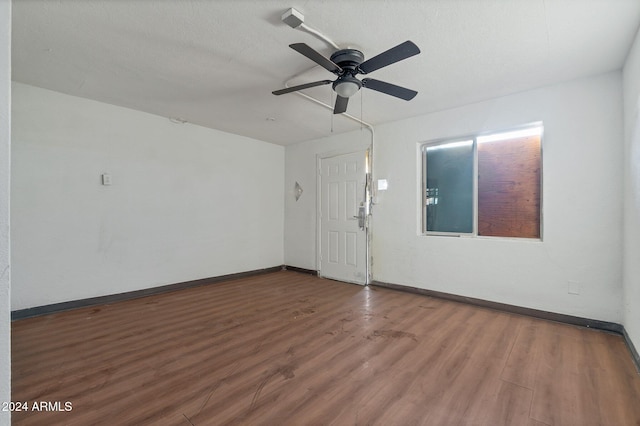 spare room with dark hardwood / wood-style floors, ceiling fan, and a textured ceiling