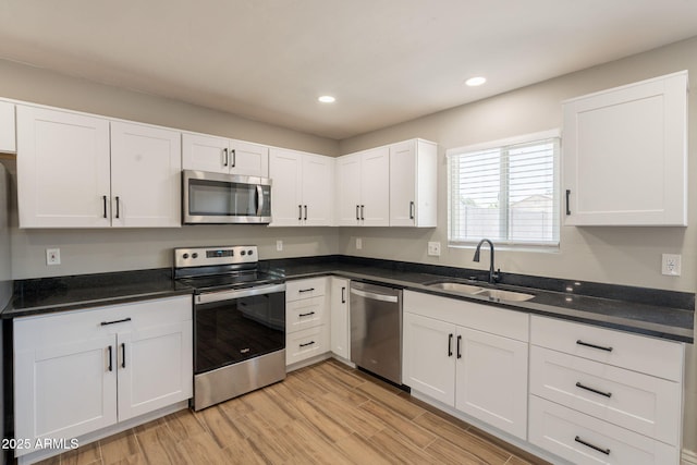 4001 E Apollo Rd, Phoenix, AZ 85042 - kitchen with appliances with stainless steel finishes, white cabinets, light wood-type flooring, and recessed lighting