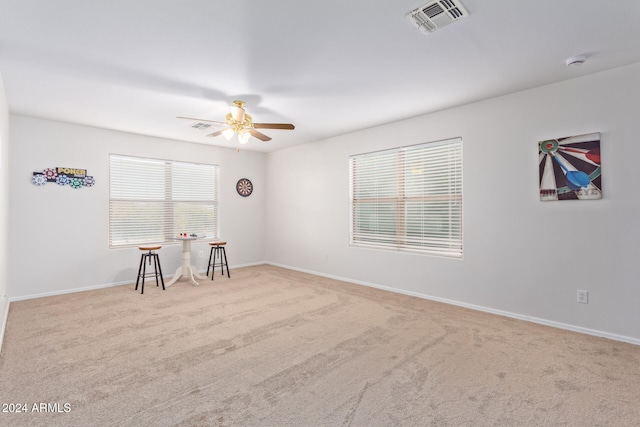 carpeted spare room with ceiling fan