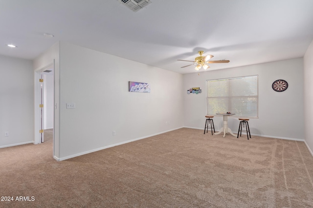 carpeted spare room featuring ceiling fan