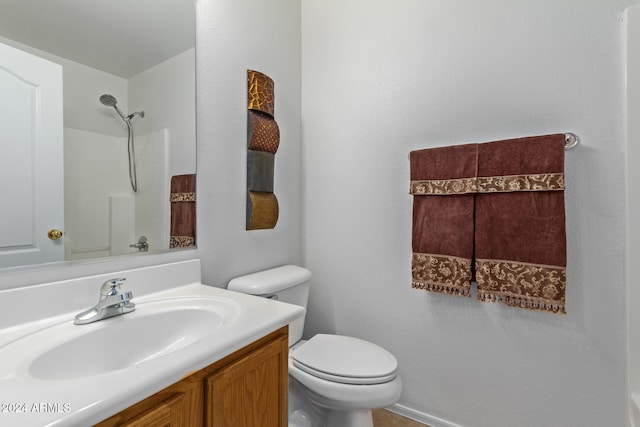 bathroom featuring vanity, toilet, and walk in shower