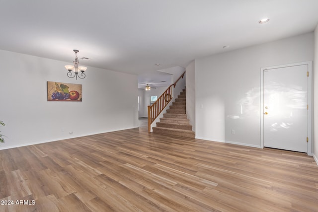 unfurnished living room featuring light hardwood / wood-style floors and ceiling fan with notable chandelier
