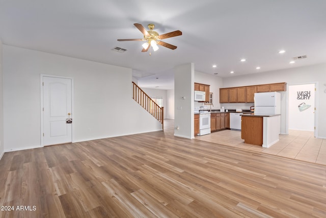 unfurnished living room featuring ceiling fan and light hardwood / wood-style flooring