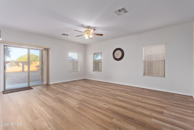 empty room with ceiling fan and light hardwood / wood-style flooring