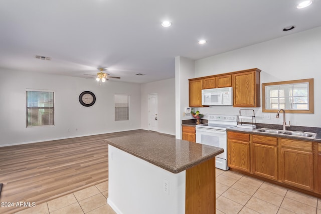 kitchen featuring ceiling fan, sink, light hardwood / wood-style floors, white appliances, and a kitchen island