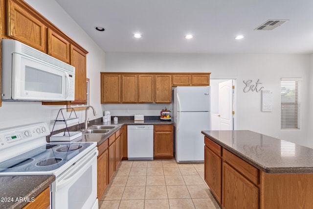 kitchen featuring dark stone countertops, white appliances, sink, and light tile patterned floors