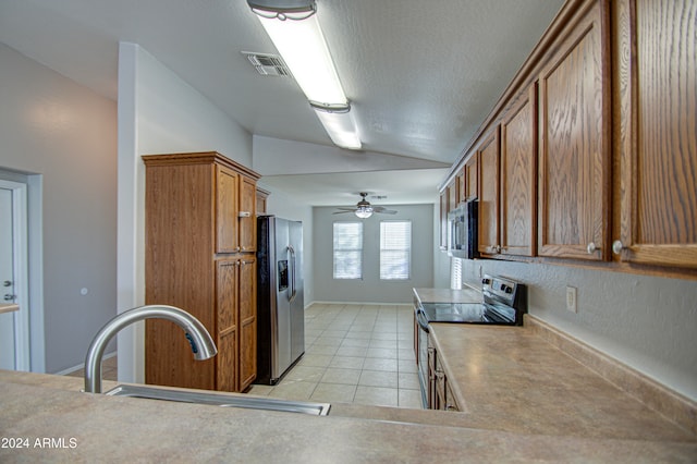 kitchen featuring ceiling fan, sink, stainless steel appliances, a textured ceiling, and light tile patterned floors