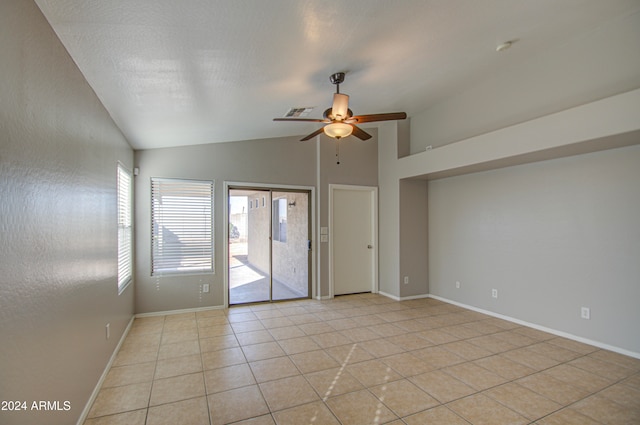 spare room with ceiling fan, light tile patterned floors, and lofted ceiling