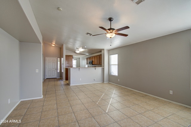 unfurnished living room with ceiling fan, light tile patterned flooring, and lofted ceiling