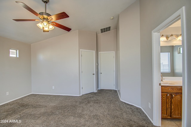 interior space featuring light colored carpet and ceiling fan