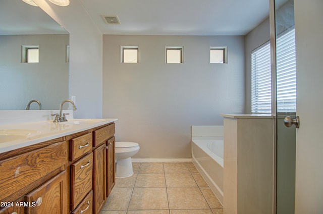 bathroom with tile patterned floors, a bathing tub, plenty of natural light, and vanity