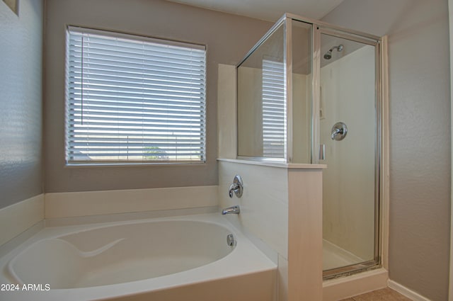 bathroom with a healthy amount of sunlight and shower with separate bathtub