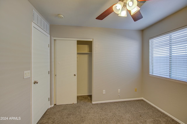 unfurnished bedroom with ceiling fan, light carpet, and a closet