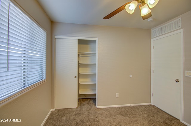 unfurnished bedroom featuring ceiling fan, light colored carpet, and multiple windows