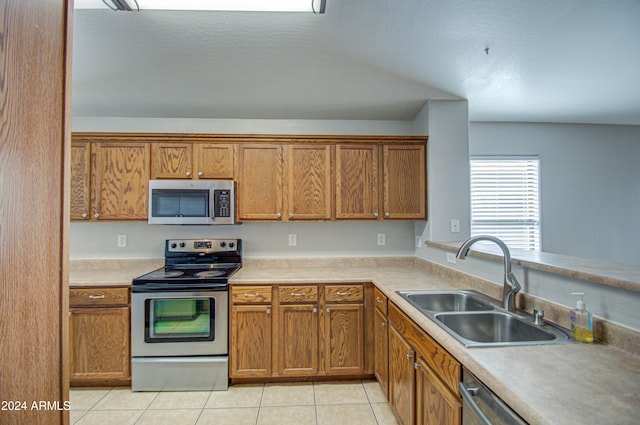 kitchen with sink, light tile patterned floors, and appliances with stainless steel finishes