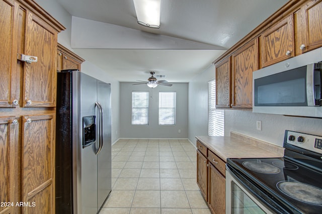 kitchen featuring light tile patterned floors, stainless steel appliances, vaulted ceiling, and ceiling fan