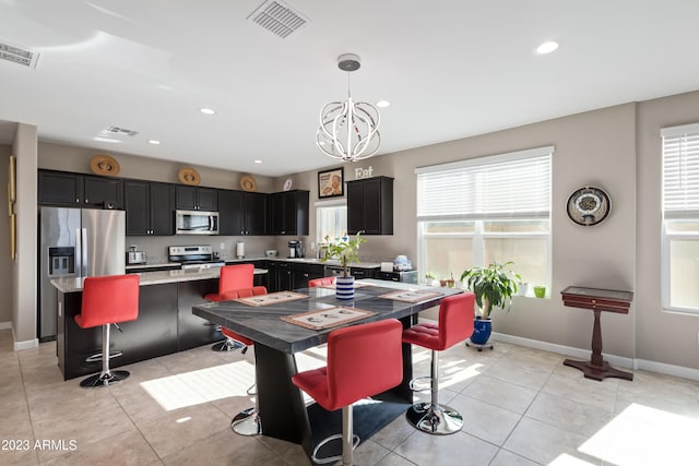 dining space featuring a healthy amount of sunlight, a notable chandelier, and light tile patterned floors