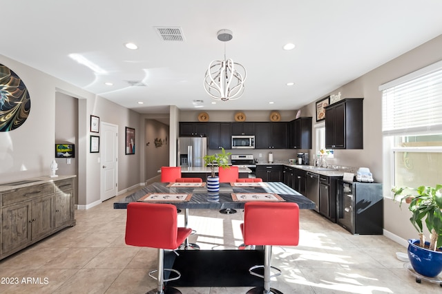 kitchen featuring light tile patterned floors, a chandelier, stainless steel appliances, and a kitchen island