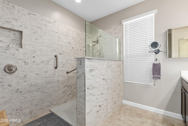 bathroom featuring tile patterned floors, tiled shower, and vanity