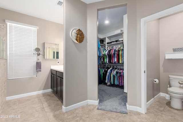 bathroom featuring toilet, vanity, and tile patterned flooring