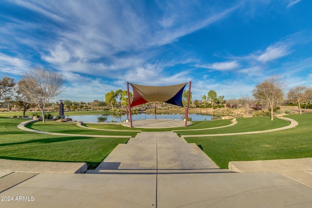 view of property's community with a lawn and a water view