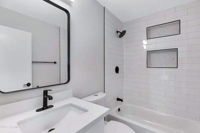 full bathroom with toilet, vanity, and tiled shower / bath