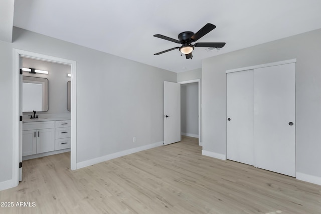 unfurnished bedroom with light hardwood / wood-style flooring, ensuite bathroom, a closet, ceiling fan, and sink