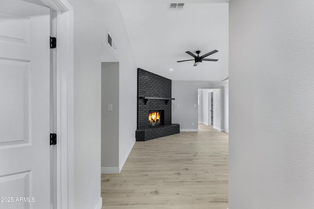 hallway with vaulted ceiling and light hardwood / wood-style flooring