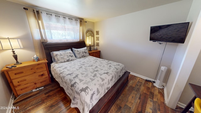 bedroom with dark hardwood / wood-style floors