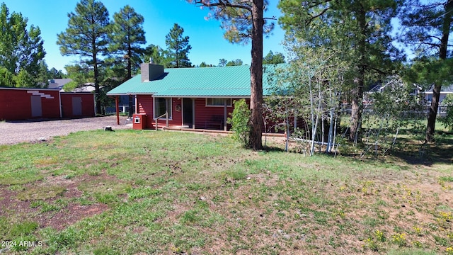 back of house featuring a garage and a yard