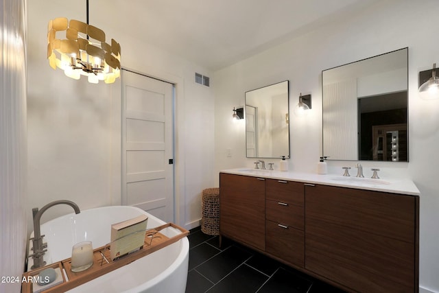 bathroom featuring a notable chandelier, a washtub, tile patterned floors, and vanity