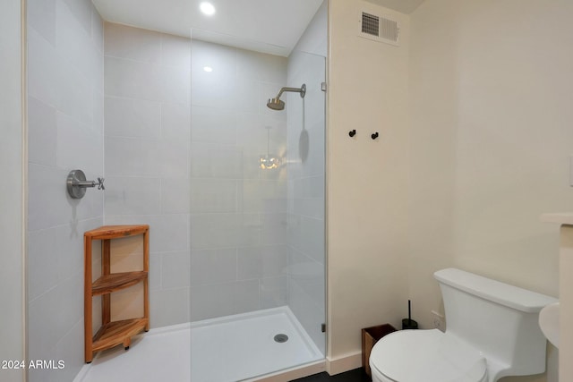 bathroom featuring toilet and tiled shower