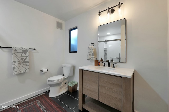 bathroom featuring tile patterned flooring, vanity, and toilet