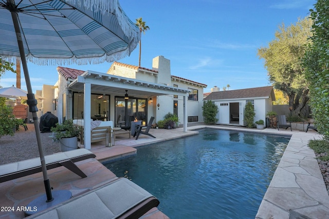 view of pool with a patio area, ceiling fan, and an outdoor structure